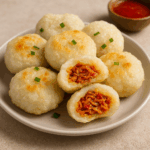 Cireng isi pedas rumahan tersaji di atas piring putih dengan isian ayam pedas yang menggoda dan saus cocolan di latar belakang.